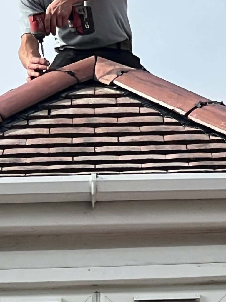 This is a photo of one of the operatives of LS Roofing Beaconsfield installing new ridge tiles