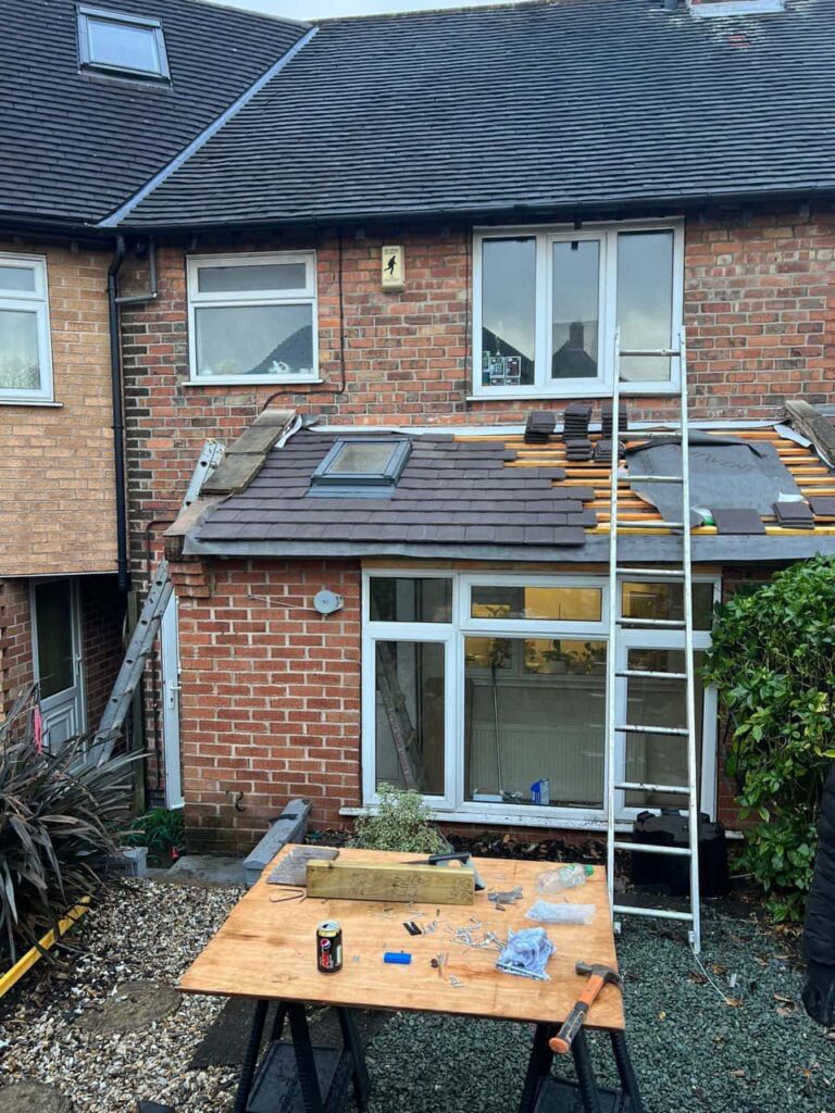 This is a photo of a roof extension that is having new roof tiles installed. This is a photo taken from the roof ridge looking down a tiled pitched roof on to a flat roof. Works carried out by LS Roofing Beaconsfield